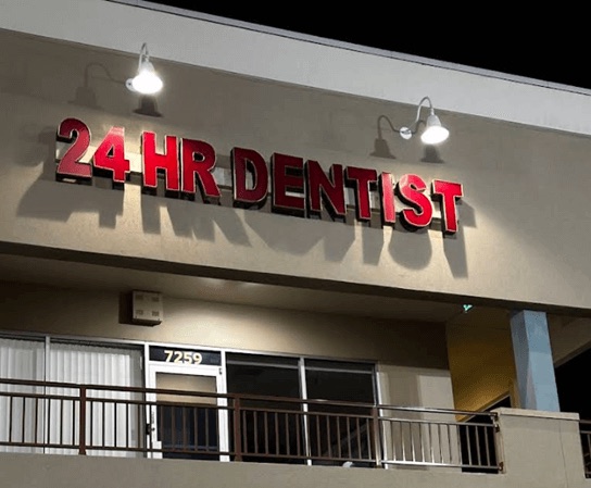 The lit 24 HR DENTIST sign above the office on International Drive, Orlando, at night